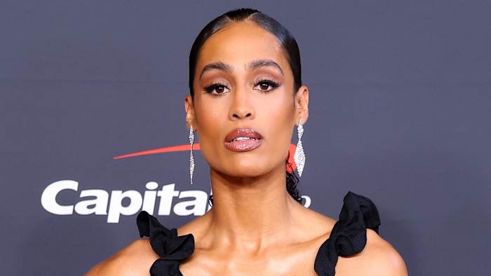 Skylar Diggins-Smith poses for the camera in a ruffled black dress.